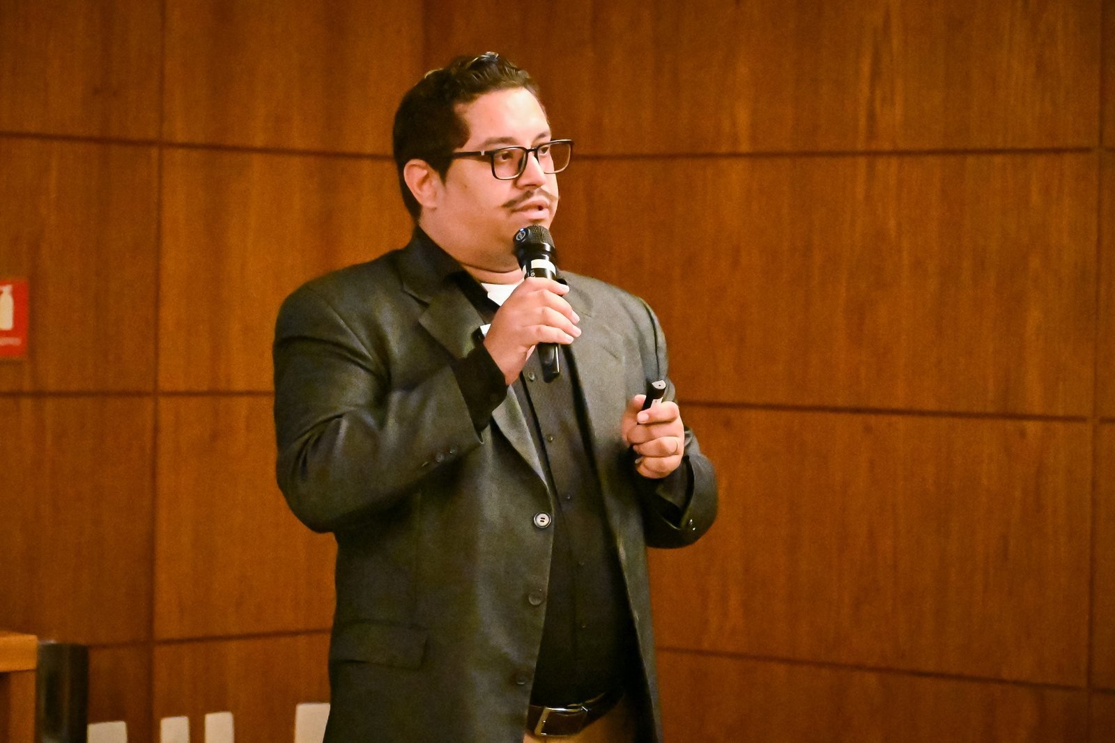 André Santana ministrando palestra com microfone em um auditório